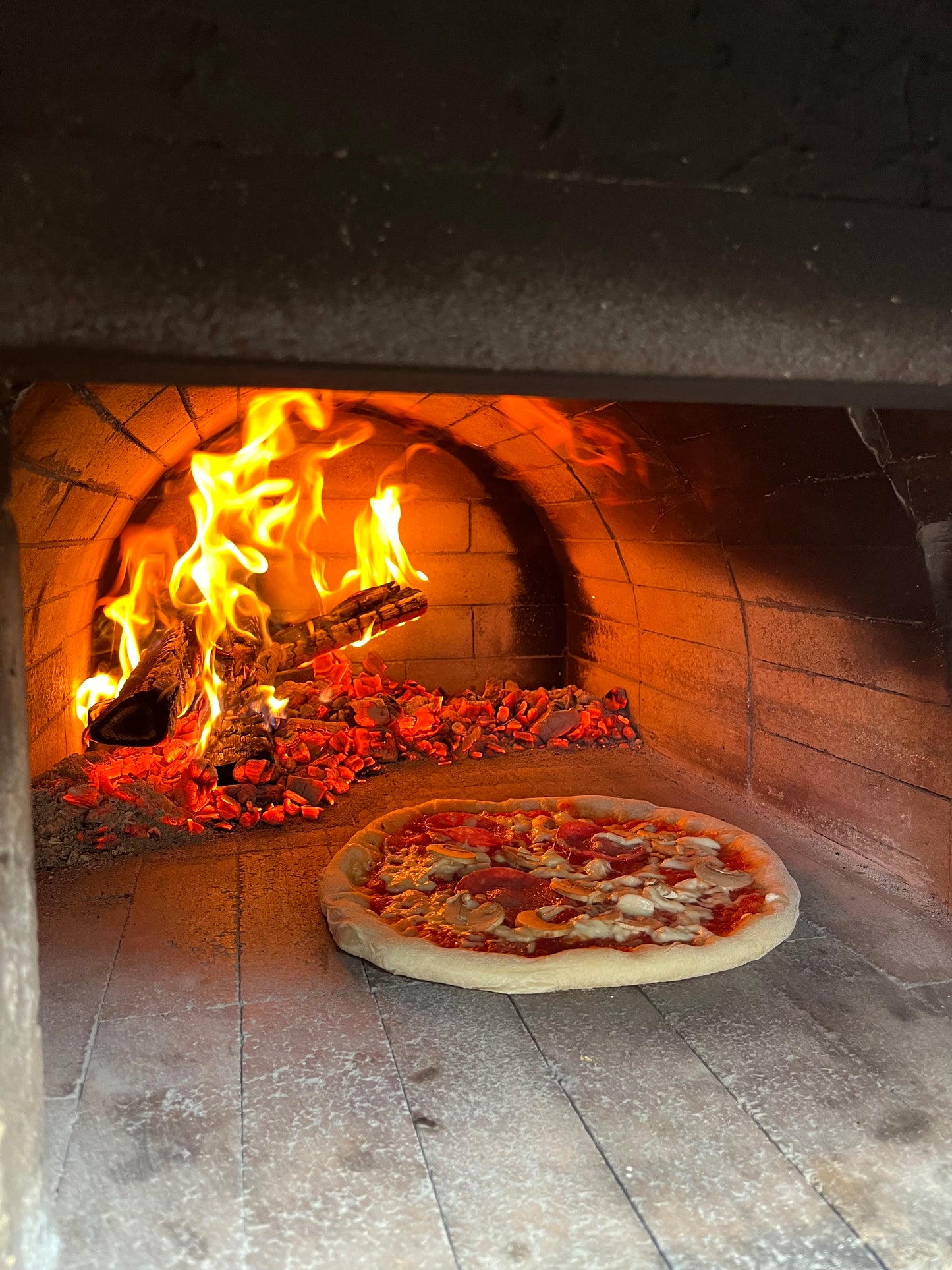 pizza cooking in a wood fired oven