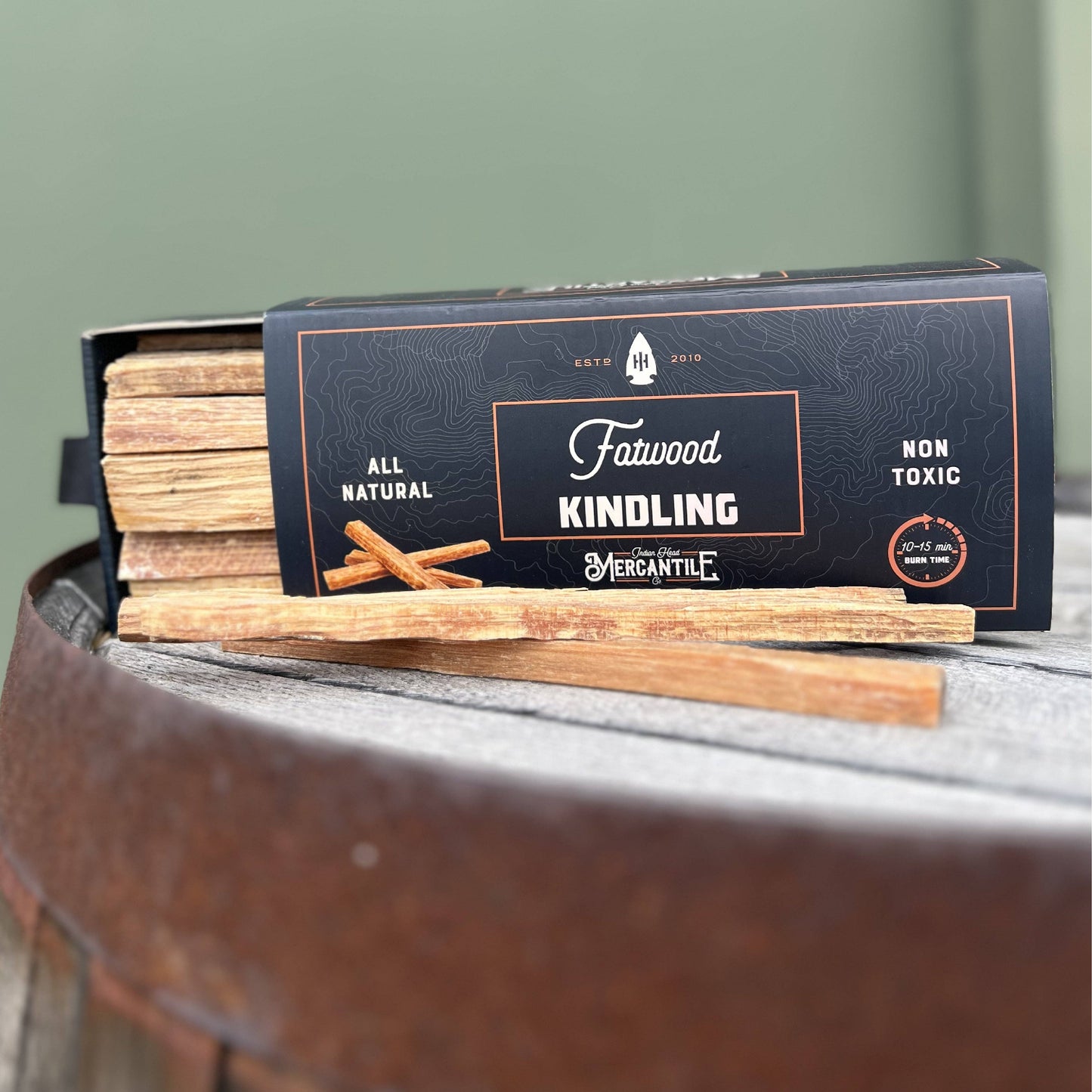 Box of Fatwood Kindling with kindling sticks on a metal surface