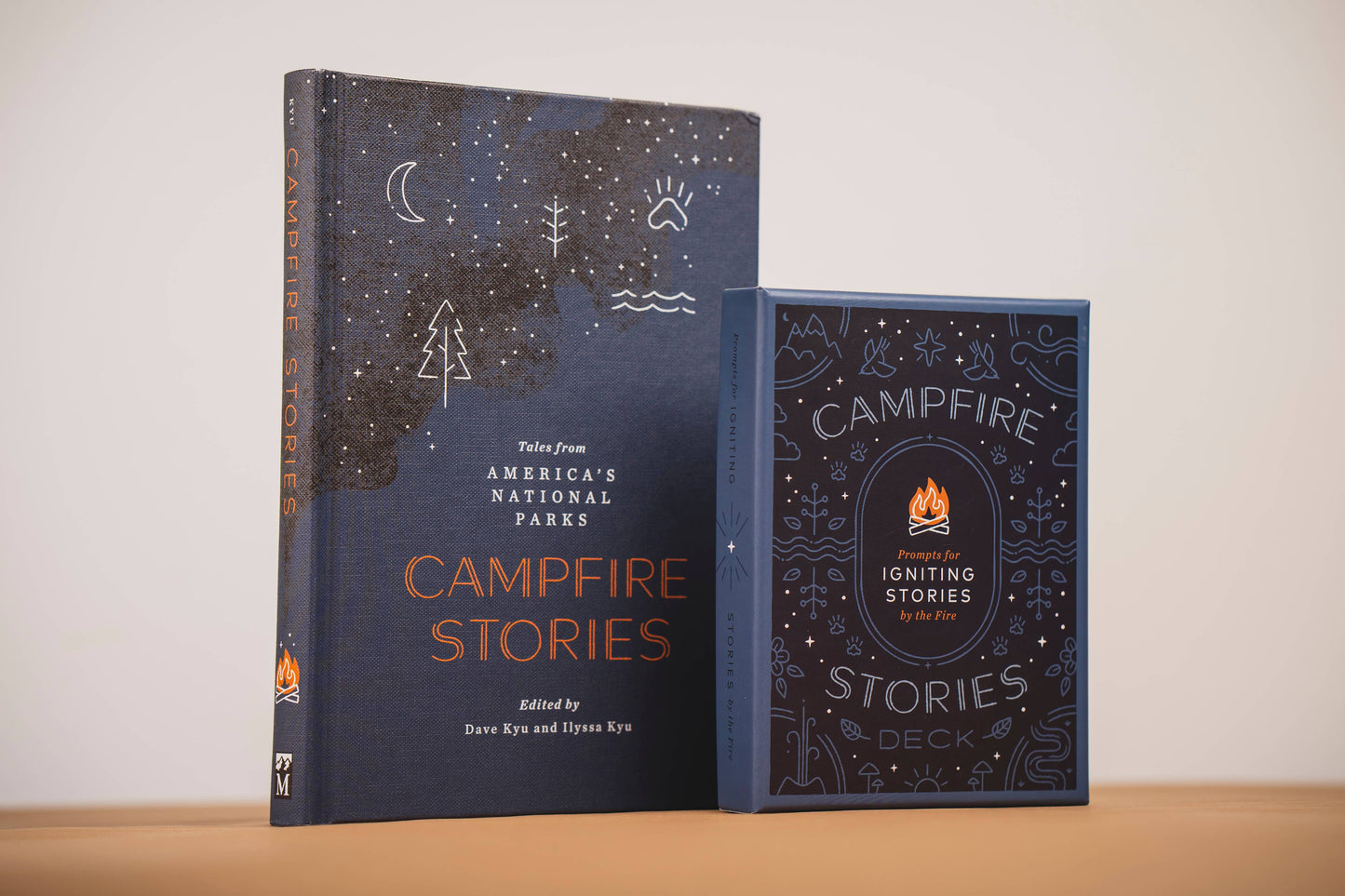 Two books titled 'Campfire Stories' on a wooden surface with a white background